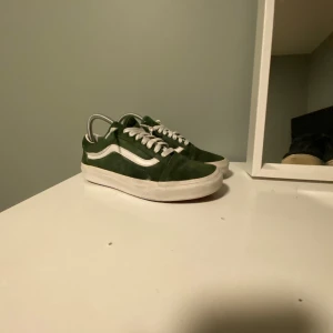 Gröna sneakers från Vans - Snygga gröna Vans sneakers med vit sula och klassisk sidostrip. Skorna har snörning och en rund tå, perfekt för en avslappnad stil.Har tyvärr inte någon box