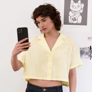 Gul kortärmad skjorta från Bershka - Snygg gul kortärmad skjorta från Bershka i ett lätt och luftigt material. Skjortan har en klassisk krage och knappar framtill, perfekt för varma dagar. Storlek xs