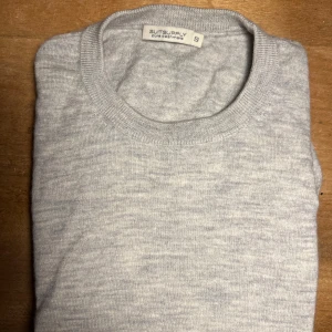 Grå kashmirtröja från Suitsupply -  mjuk grå kashmirtröja från Suitsupply med ett nypris på 2100kr. Tröjan har en klassisk rund hals och långa ärmar, perfekt för en stilren look. Den är tillverkad i 100% kashmir.
