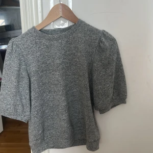 Grå tröja från 157 - Säljer en stilren grå tröja från 157 med trekvartsärm. Perfekt för en avslappnad look. Tröjan har en rund hals och är tillverkad i ett mjukt material.
