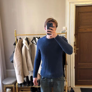 Mörkblå tröja från Massimo Dutti (M) - Säljer en stilren mörkblå tröja från Massimo Dutti. Den har en klassisk rund hals och ribbade muddar vid ärmslut och nederkant. 88% ull 12% polyamide. Storlek M. Den är i bra skick men är lite nopprig 