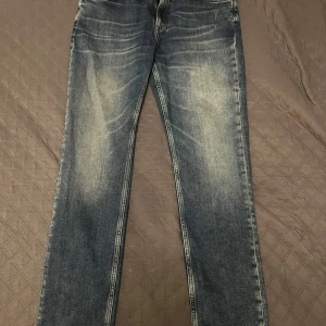 Slim fit jeans med slitningar - Snygga blå jeans med en klassisk femficksdesign som är i nyskick. Använda bara en gång  och coola slitningar för en avslappnad look. De har en normal passform och är perfekta för en casual stil. Jeansen har en dragkedja och knapp framtill. Priset är ej hugget på den