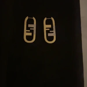 Guldörhängen från Fendi - Snygga guldörhängen från Fendi med en unik design och glittriga detaljer. Perfekta för att ge en lyxig touch till din outfit.