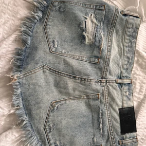 Ljus jeanskjol one teaspoon  - Snygg ljusblå jeanskjol från one teaspoon med slitna detaljer. Har inte hittat liknande.. nya ligger runt 1 500. Den har jättefint skick