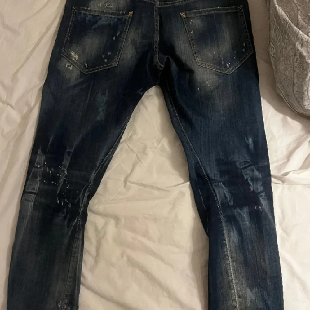 Snygga blå jeans från Dsquared2 med slitna detaljer och en cool tvätt. De har en klassisk femficksdesign och en knappgylf. Perfekta för en avslappnad stil.. Farkut & Housut.