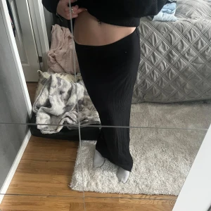 Svart långkjol - Säljer en elegant svart långkjol som passar perfekt för olika tillfällen. Kjolen har en enkel och stilren design som gör den lätt att matcha med olika toppar. Perfekt för dig som vill ha en tidlös och mångsidig garderob.