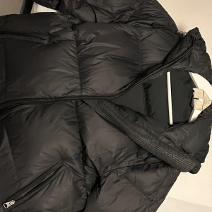 Svart dunjacka  Arket - Säljer en svart dunjacka från Arket, superfint skick och bra kvalité! Nypris 2790kr! Säljer för att den inte kommer till användning längre :) 💓Är osäker på storleken men den passar bra på mig som är S, borde även passa M ! 