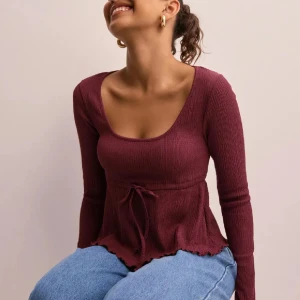 Vinröd ribbad topp - Snygg vinröd ribbad topp med långa ärmar och knytning i midjan. Knappt använd, slutsåld på hemsidan!🥰