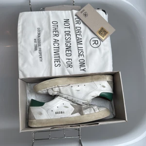 Golden Goose Superstar - Säljer dessa superfina Superstars från Golden Goose i en unik grön färg med en snygg brun innersida av läder. Köpta i deras butik i Italien, därav allt OG samt ”Golden goose passport” medföljer även. Nypris ca 6700kr/ 645€. Storlek 42, skriv vid frågor om pris osv!😊