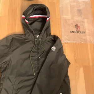 Moncler Windbreaker - Tja säljer denna feta windbreaker från Moncler. Toppskick, ändast använd ett par fåtal gånger. Passformen är sisådär men ändå relativt bra. Sitter ganska dåligt nere vid midjan. Dock så tänker man inte på det så mycket. Drags kedjan är också lite trög. Passar L/M.