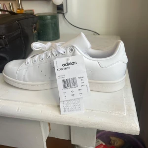 Vita Adidas Stan Smith sneakers - Säljer ett par helt nya stan Smith sneakers som jag fick i present och var tyvärr för stora. Dom är i storlek 38 och 2/3 och är helt oanvända med prislapp kvar. Dom är köpta för 1100kr och säljer för 750🥰