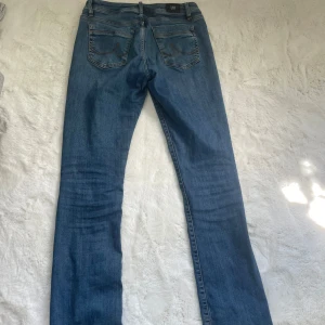 Blå jeans från ltb W29 L34 - Snygga blå jeans från ltb i modellen Valerie med klassisk femficksdesign och raka ben. Jeansen har en normal passform och är tillverkade i slitstarkt denimmaterial. Perfekt för dig som gillar en enkel och tidlös look. Midjan är low waist och färgen är en klassisk blå tvätt . Lite slitet längst ned på byxorna ( skriv för bild)