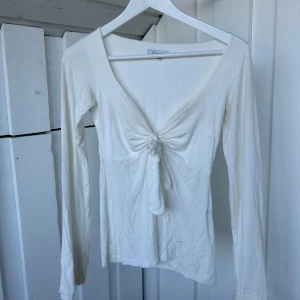 Vit långärmad topp med knyt från Design by Si - använd fåtal gånger och finns missfärgning! Men ska lätt gå bort i tvätten🤍