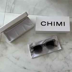 CHIMI 04 grey  - Snygga solglasögon från CHIMI med transparent grå båge och fyrkantig form. Glasen är mörktonade och bågarna har en cool, modern vibe. Kommer med originalfodral och box. Perfekt accessoar för att lyfta din stil. Nypris 1400kr 💘