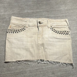 Beige jeanskjol med nitar från Replay - Jättesnygg beige jeanskjol från Replay, köpt second hand men nästan aldrig använt den själv. Bakfickorna har dragkedja som går att öppna. Kjolen passar XS, S och M den är väldigt stretchig och skön.