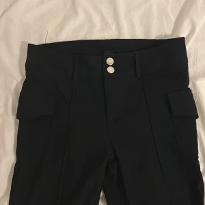 Svarta kostymbyxor!!  Utsvängda där nere. - Jätte fina enkla&stilloga kostymbyxor med  dubbla silvriga knappar i midjan. 
