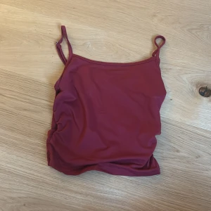 Vinröd linnetopp i storlek XS - Säljer en vinröd linnetopp från SHEIN i storlek XS. Toppen har smala, justerbara axelband och rynkade sidor för en snygg detalj. Materialet är mjukt och stretchigt. Aldrig använd!!! Pris kan diskuteras!