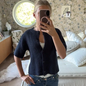 Mörkblå kofta från Gina Tricot - Säljer en mysig mörkblå kofta från Gina Tricot med kort ärm och rund hals. Har nästan aldrig använt. Säljer för att ja inte använder den❤️