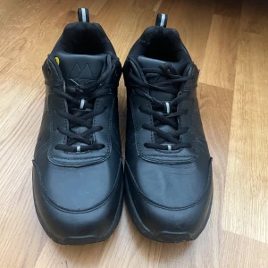 Svarta Monitor skyddsskor – modell 100406‑01, storlek EU 46 – EN ISO 20347 - Använda ett par gånger men fortfarande i mycket gott skick, ser ut som nya.  Originalprodukt från Monitor Bekväma, lätta och ventilerande  Halksäker sula (SRC) och ESD‑godkända Perfekta för lager, industri eller servicearbete Säljes pga ej längre behov.