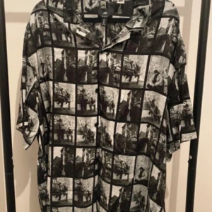 Svartvit fotomönstrad skjorta H&M L - Cool skjorta från H&M i relaxed fit med svartvitt fotomönster över hela plagget. Skjortan har korta ärmar, klassisk krage och knäppning framtill. Perfekt för dig som vill sticka ut med en unik streetstyle-look.