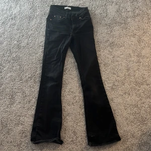 Svarta bootcut jeans från Perfect Jeans - Snygga svarta jeans från Perfect Jeans i storlek 32. Modellen har bootcut-ben, klassiska fem fickor och dragkedja med knapp. Jeansen är i stretchigt denim och har en stilren look som passar till allt.