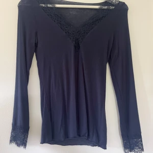 Blå spetsblus från Intimissimi - Supersnygg blå blus från Intimissimi med v-ringning och spetsdetaljer vid halsringning och ärmslut. Inte använd 