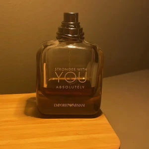 Emporio Armani Stronger With You - Emporio Armani Stronger With You Absolutely är en elegant herrparfym i en mörkbrun, fyrkantig glasflaska med svart spraykork. Flaskan har stilren text i vitt och guld. Doften är intensiv och modern, perfekt för dig som gillar exklusiva och maskulina parfymer. Skriv om pris eller något du undrar. 