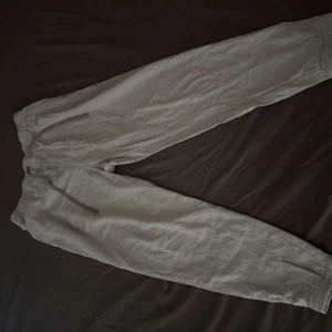 Vit linnebyxor från Zara med snörning - Snygga vit linnebyxor från Zara i storlek M. Byxorna har elastisk midja med snörning och ribbade muddar vid bensluten. De har en bakficka och är perfekta för chill dagar eller när du vill ha en avslappnad look.