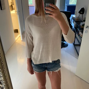 Beige stickad tröja från Zara - Säljer en beige stickad tröja från Zara Fancy Collection. Tröjan har rund hals, trekvartsärm och är lätt och luftig i materialet. Perfekt för sommaren och har en clean, enkel look som funkar till jeans eller shorts. Ribbad kant vid hals och ärmslut.