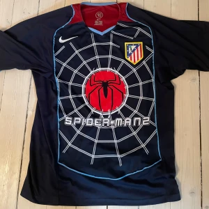 Atletico Madrid Spider-Man tröja Torres - Atletico Madrid fotbollströja med Spider-Man tema. F. Torres samt nummer 9 i gult på ryggen. Använd någon enstaka gång.