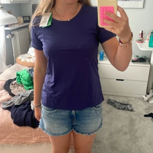 Blå tränings-tshirt från SOC - Snygg blå t-shirt från SOC i sportig stil, perfekt för löpning eller gym. Modellen är kortärmad med rund hals och har en clean design utan mönster. Materialet är lätt polyester som andas och torkar snabbt. Reflekterande detaljer på ryggen för extra synlighet. Har aldrig använts. 