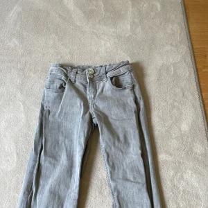 Grå bootcut jeans med låg midja - Snygga grå jeans lågmidjade. Väldigt bra skick jag har använt dem två gånger! Kan tänka mig sänka Priset! Dem går inte att köpa Längre.
