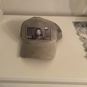 velvetkeps från OneCap - Säljer en adriana Lima velvetkeps från OneCap med mesh på sidorna och baksidan för extra ventilation. Framtill finns en unik patch med motiv och OneCap-logga. Kepsen har justerbar plastrem och snyggt broderad logga på insidan. Perfekt för dig som gillar streetwear.