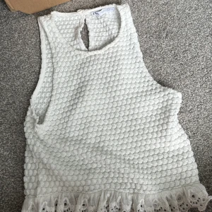 Vit ärmlös topp från Zara med spets - Superfin vit ärmlös topp från Zara med bubblig struktur och söt spetskant nertill. 