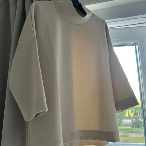 Beige tröja från Carin Wester - Stilren beige tröja från Carin Wester med hög krage och trekvartsärmar. Tröjan har en loose passform och är gjord i mjuk bomullsmix, perfekt för dig som gillar minimalistisk och clean stil. Aldrig använd. Storlek xs passar även s och m beroende på hur man vill att den ska sitta. 💕💕