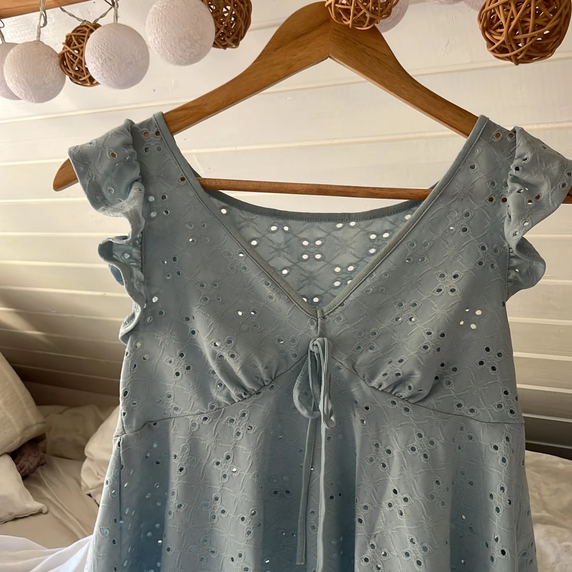 Ljusblå blus med broderade hål och volang - 2