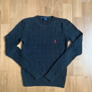 Svart kabelstickad tröja Ralph Lauren - En svart stilig Cable Knit från Ralph Lauren.  Längd 52 cm, bredd 36.   Barnstorlek S.  Fraktar oftast samma dag!!