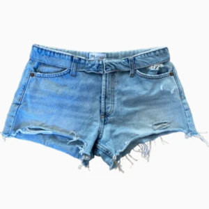 Blå jeansshorts med slitna detaljer - Snygga lågmidjade jeans shorts från Zara. Bra skick och i storlek 36. Det är ljusblå och perfekta för sommaren😍