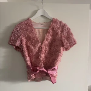 Rosa blommig blus från Ida Sjöstedt - Superfin rosa blus från Ida Sjöstedt med knyt i midjan. Säljer då den inte kommer till användning längre🥰
