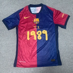 FC Barcelona Lamine Yamal Player Edition - Snygg FC Barcelona matchtröja från Nike med Lamine Yamal och nummer 19 på ryggen. Tröjan har klassisk halva-röd halva-blå design, gula detaljer och klubbmärke på bröstet. Tillverkad i lätt, ventilerande Dri-FIT material. Perfekt för dig som älskar Barca och vill sticka ut på planen. Tröjan är i spelarkvalité.