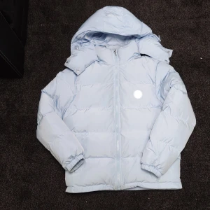 Ljusblå pufferjacka irongate från Trapstar  - Säljer en ljusblå pufferjacka från Trapstar i storlek M Jackan säljs inte längre och är därför exklusiv. Trapstar Irongate Jacket – Baby Blue  Gör ett statement med den exklusiva Trapstar Irongate Jacket i färgen Baby Blue – en ikonisk jacka som kombinerar streetwear med lyxig edge. Jackan har en lätt glansig yta och är tillverkad i högkvalitativt, vattenavvisande material. Den har används fåtal gånger, och har inga skador. Ny pris ligger runt 7-8 tusen