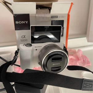 Sony α5000 - Sony α5000 är en kompakt systemkamera med , vinklingsbar skärm och WiFi. Perfekt för dig som vill ta snygga bilder / vlogga och skicka direkt till din mobil via WIFI.  Levereras med originalkartong, 16-50mm objektiv. Enda som saknas är en liten kabel till laddaren. 