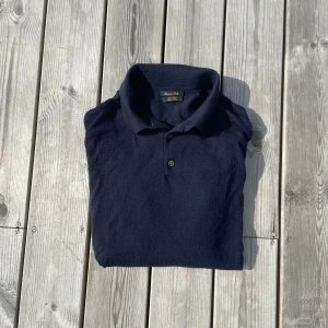 Mörkblå merinoull pikétröja Massimo Dutti - Snygg mörkblå långärmad pikétröja från Massimo Dutti i mjuk merinoull. Tröjan har en slimmad passform och är i storleken S