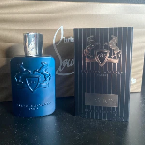 Parfums de Marly Layton 125ml - Lyxig parfym från Parfums de Marly, Layton, i en snygg mattblå flaska med silverfärgad kork och upphöjt emblem med två hästar. Kommer i elegant svart kartong med silverdetaljer. Flaskan rymmer 125 ml Eau de Parfum och har en exklusiv vibe.