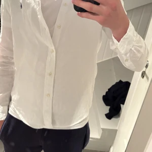 Vit linneskjorta från Polo Ralph Lauren - Klassisk vit skjorta från Polo Ralph Lauren i luftig linne. Broderad marinblå logga på bröstet ger en clean och stilren look | Skick: 9/10 som ny | Ny pris: 1200kr - Mitt pris: 399kr | Storlek: L (Barn) - Passar XS - S beroende på hur du vill att skjortan ska sitta | var inte rädd att höra av dig vid funderingar 📩