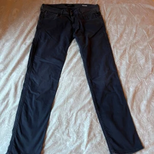 Replay Anbass mörkblå jeans, stl 32 - Säljer ett par snygga Replay Anbass jeans i mörkblå färg. Klassisk femficksmodell med raka ben och diskret Replay-logga på bakfickan. Jeansen är tillverkade i mjuk bomull med lite stretch för extra komfort. Hör gärna av er för intresse✨