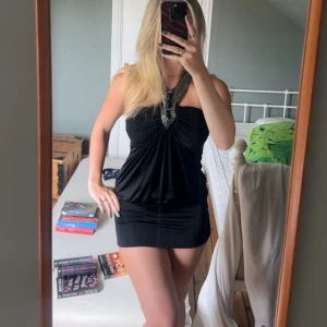 Svart kort klänning med smyckad halterneck - Supersnygg svart kort klänning med halterneck och glittriga detaljer. Prislappen är kvar (sista bilden). Står ej storlek men skulle gissa på storlek small. Endast testad 😊