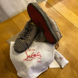 Christian Louboutin loubs skor - Gråa Christian Louboutin skor med nitar, slitage finns så som att tre nitar är borta på ena skon, slitage mm där av priset. Billigare vid snabb affär! Tveka inte att fråga något svarar så fort jag kan. Kör också även på byten!😁