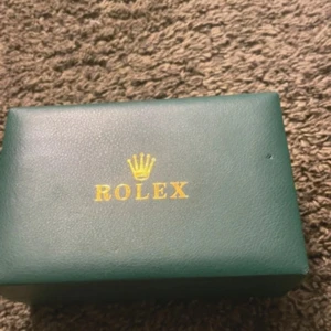 Klocka i guld och silver - Säljer en snygg klocka i klassisk design med tvåfärgad länk i guld och silver. Urtavlan är vit med glittrande stenar som index och datumvisning. Vet ej mycket märket så säljer i okej billigt pris. Skick enligt bilderna.