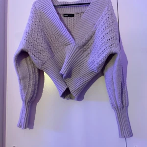 Grå omlott kofta från SHEIN - Superfin grå omlott kofta från SHEIN med bred ribbad krage och stickat mönster. Koftan är croppad och har långa ärmar med extra breda muddar. Perfekt för lager-på-lager och ger en chill men ändå snygg vibe.